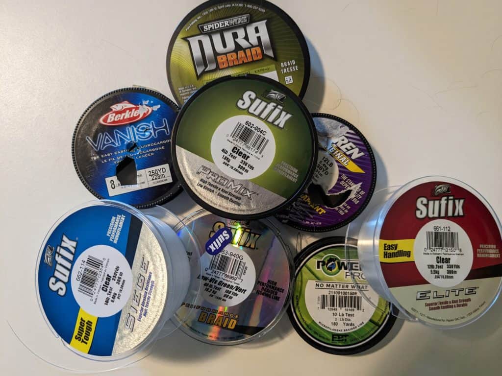 A diverse selection of top-rated fishing lines, including monofilament, fluorocarbon, and braided options, laid out for comparison – the ultimate guide to choosing the best line for bass fishing.
