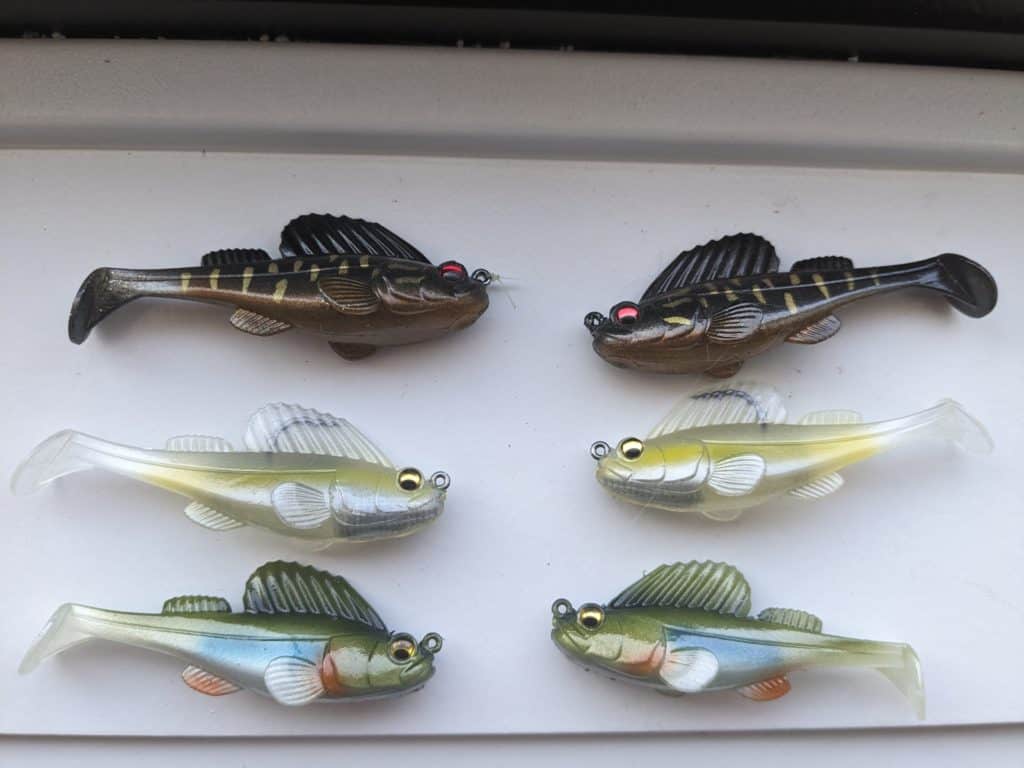 Assortment of Megabass Dark Sleeper swimbaits in various colors and sizes, popular for catching smallmouth bass