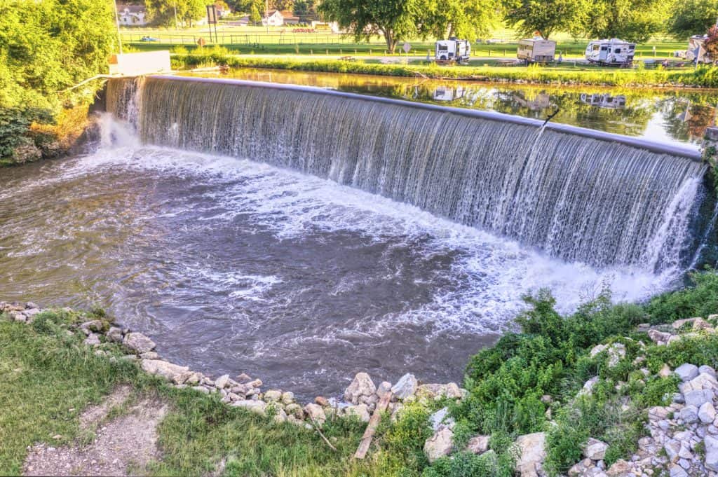 Massive dam structure with swirling waters, a coveted spot for anglers targeting bass after a storm